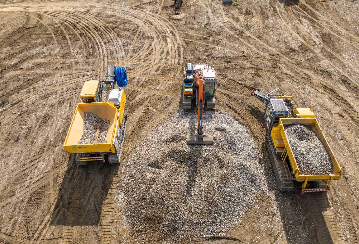 Aerial view of specialist machinery, including a tracked dumper and excavator, working on a land