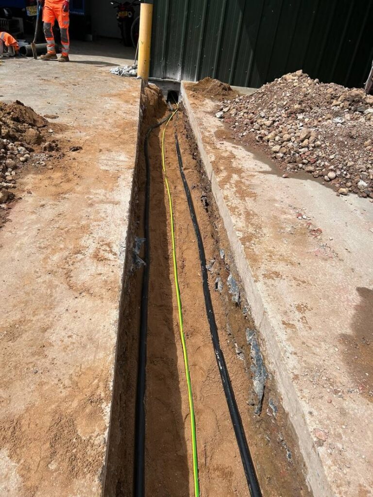 Cable ducts laid in a trench between farm buildings