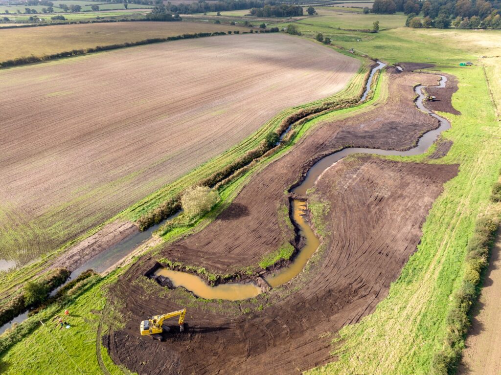 Specialist earthmoving equipment creating a new meandering river channel